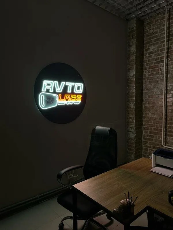 Белый световой логотип AVTO GLASS в помещении